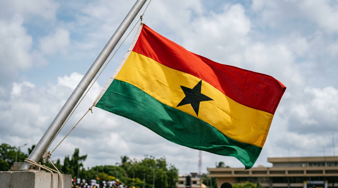 Ghana flag with red, yellow, green stripes and black star flying on a pole